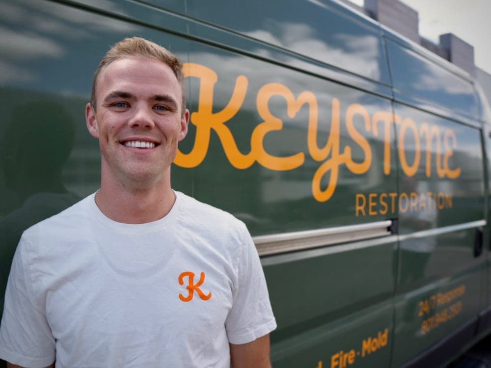 Kyle Smith, dispatcher at Keystone Restoration, in front of the company van in Bluffdale, Utah
