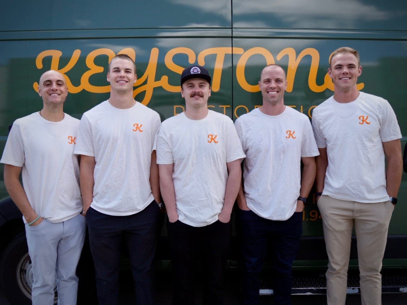 The Keystone Restoration team standing together in front of the company van in Bluffdale, Utah