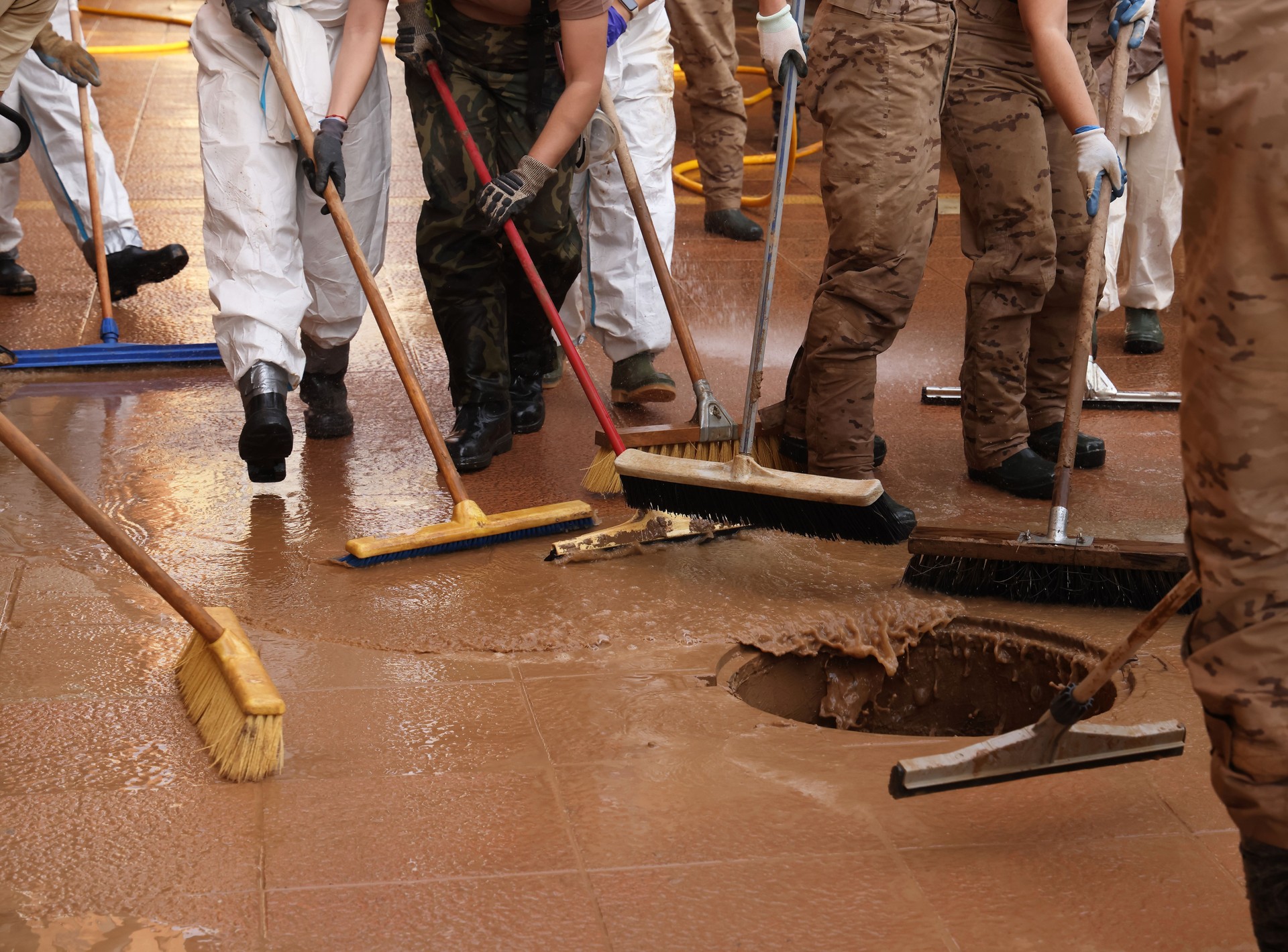 Team effort to reach the target of manhole, in clearing mud, water and other chemical residue from streets