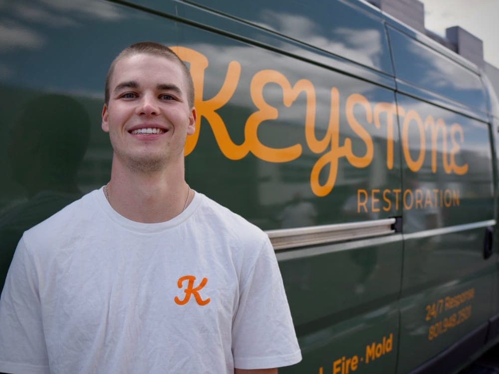 Seth Saxton, owner of Keystone Restoration, in front of the company van in Bluffdale, Utah